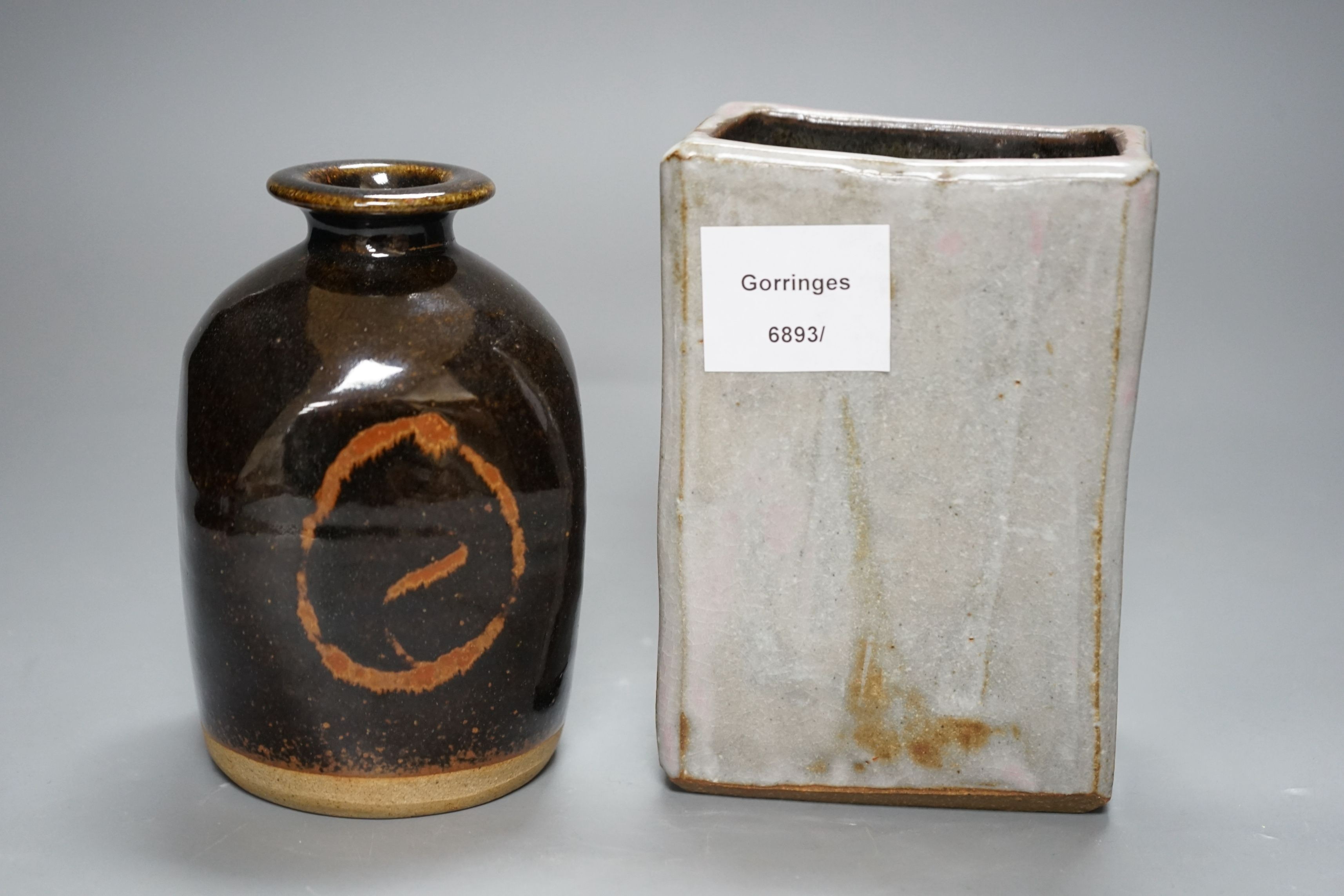 British Studio Pottery; a tenmoku glazed bottle vase, with impressed mark, together with an abstract rectangular blue glaze vase with brown and pink undertones, unmarked, 15cm tall, (2)